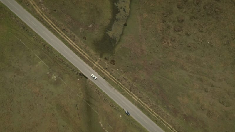 Aerial view of a car driving on road in the countryside.