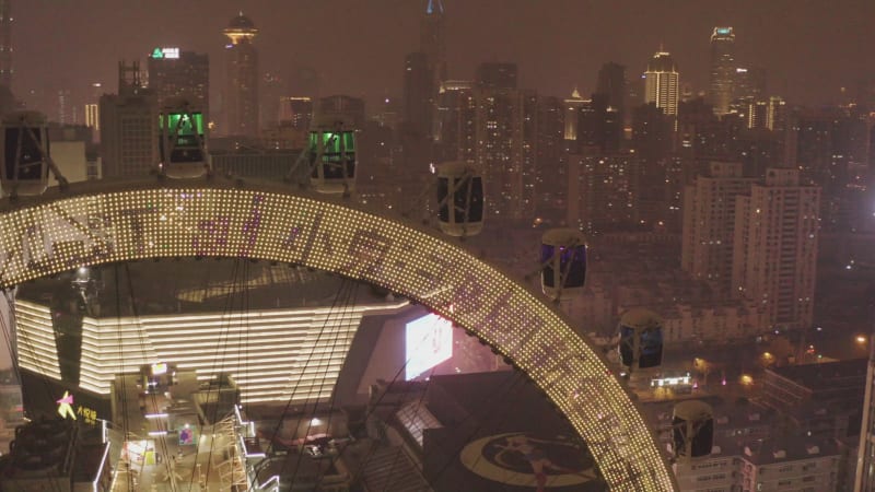 Aerial view of a Ferris wheel in Shanghai downtown at night, China.