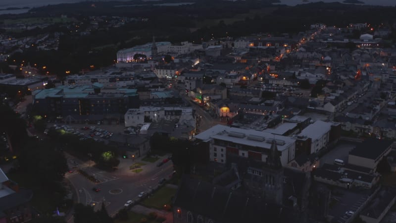 Aerial shot of city centre. Buildings and streets in evening. Cars driving on road and parking in square. Killarney, Ireland