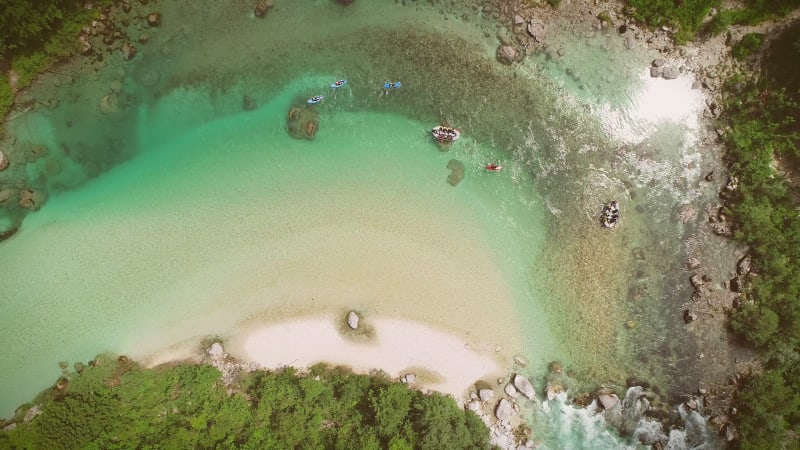 Aerial view of people doing rafting surrounded by rocks.