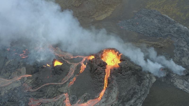 Aerial orbit of erupting Fagradalsfjall volcano with molten lava flow