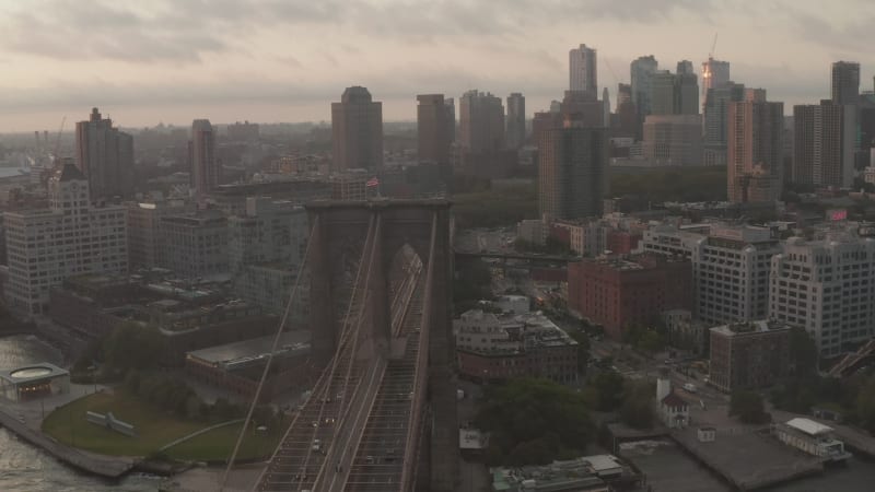 Close up circle flight over Brooklyn Bridge with american flag and foggy Manhattan New York City Skyline