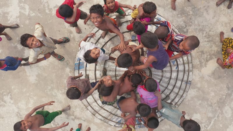Aerial view of kids playing in a rice mill field in Chittagong, Bangladesh.