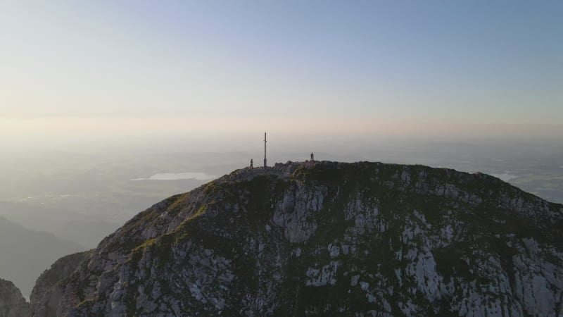 Aerial view of hiker on mountain peak during sunset