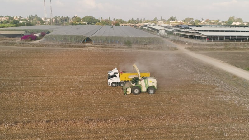 Aerial view of a tractor and a lorry working in a field, Kibbutz Saar, Israel.