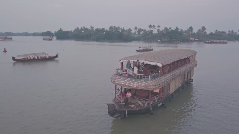 Aerial orbit of people on large wooden boat in India