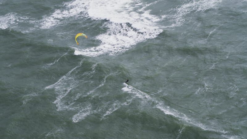 Kitesurfers in de golven op een stormachtige dag