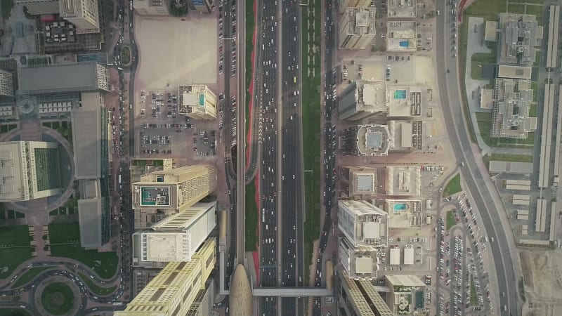 Aerial view of Dubai colourful skyscrapers, and long busy road.