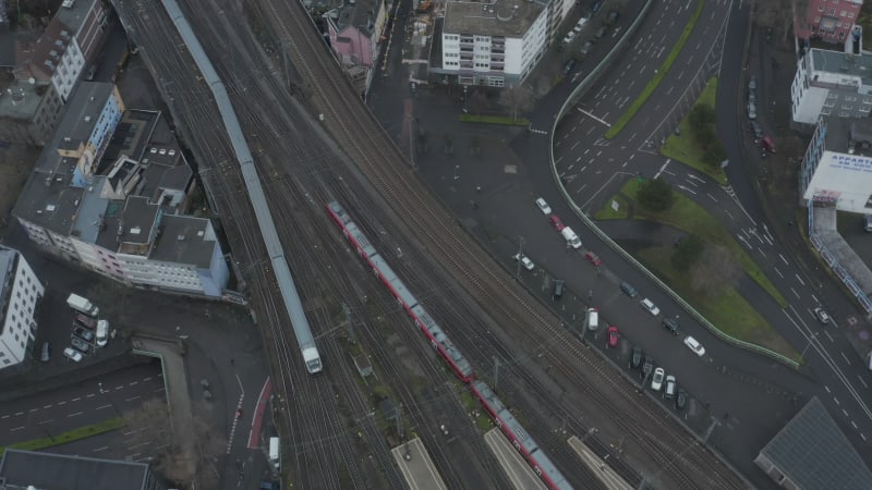 Top down footage of train leaving train station. Tracking of train unit driving on wide multitrack railway line in city. Cologne, Germany