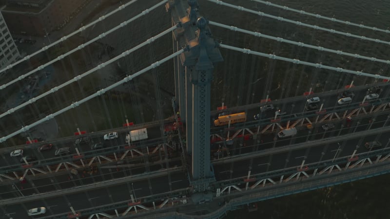 Heavy traffic on Manhattan Bridge. Tilt up reveal of cityscape against setting sun. Manhattan, New York City, USA