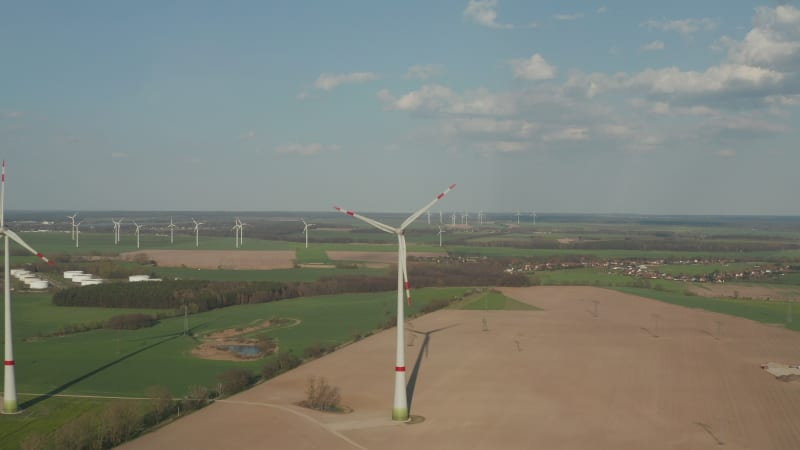 Close up Circling Wind Turbine under construction being built on rich green agriculture field