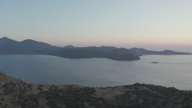 Cruise Ship passing by Islands in Greece at Sunset