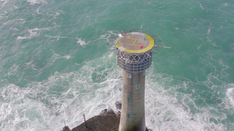 Lighthouse on a Rock in the Ocean with Crashing Waves and a Helipad