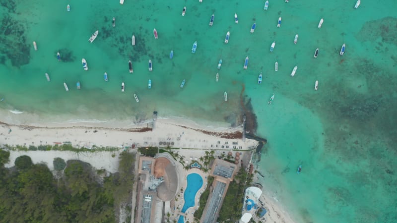 Top down aerial view with moored boats at the coastline of Caribbean Sea at Playa del Carmen, Mexico