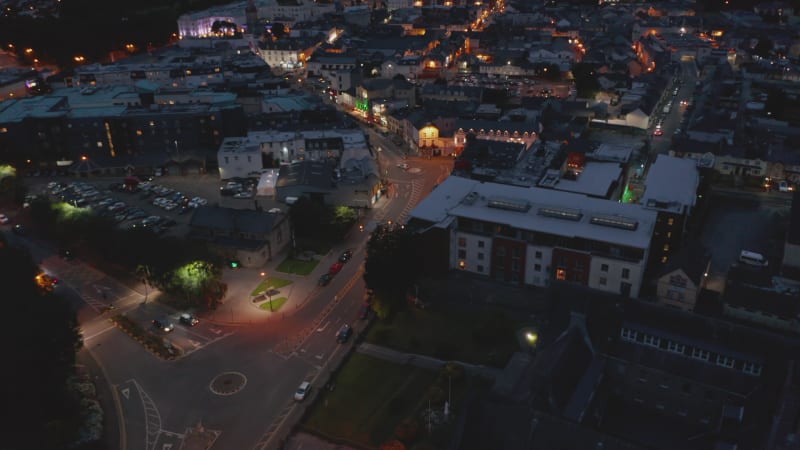 Aerial descending footage of night city. Illuminated streets and house facades in town centre. Killarney, Ireland