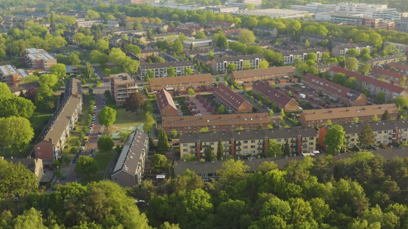 Aerial view of residential houses surrounded by green trees in The Netherlands