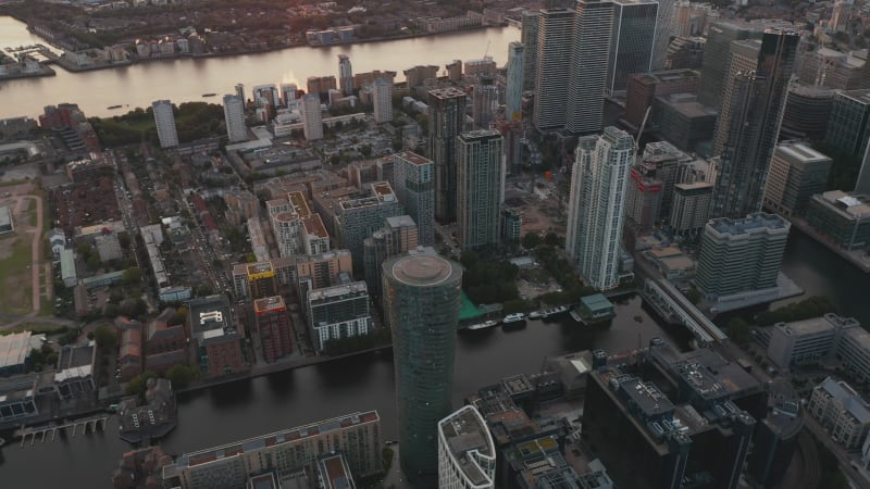 High angle view of water channel between buildings at Canary Wharf business district. Aerial view in sunset time. London, UK