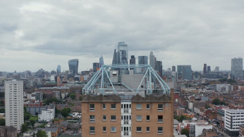 Fly over tower apartment building, revealing downtown skyline. Modern design futuristic skyscrapers in business district. London, UK