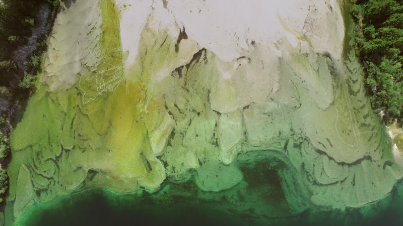 Aerial view of abstract green and transparent water in Lago del Predil.