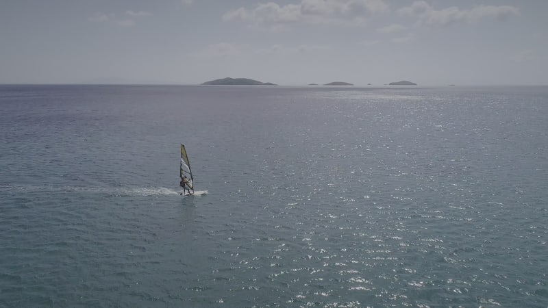 Aerial view of man doing windsurfing at a beach.