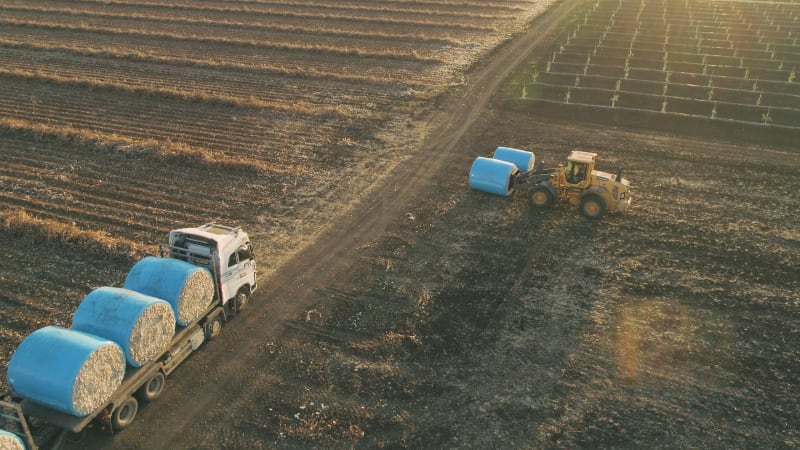 Aerial view of a tractor loading cotton bales on truck, Israel.