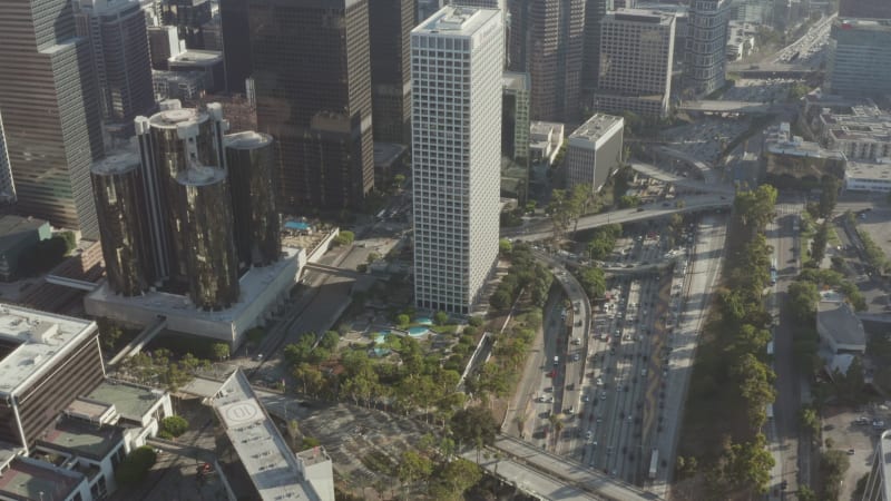 Circling Downtown Los Angeles, California intersection traffic with palm trees and Skyline in background at beautiful blue sky and sunny day