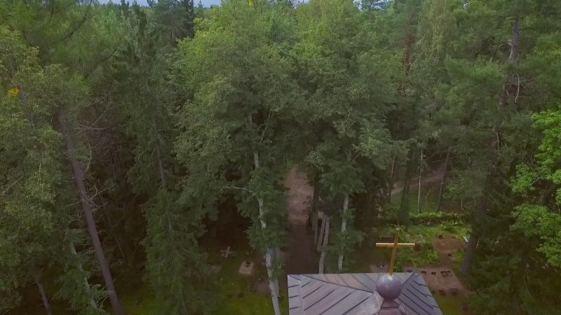 Aerial view of a forest with traditional Chapel and a cemetery.