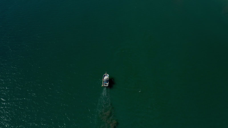 Aerial view of a small fishing boat sailing near Estepona, Malaga, Spain.