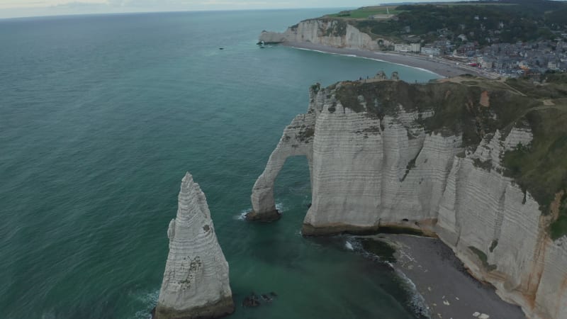 Wide Aerial Establisher of Etretat Cliffs Arch on Overcast Day with dark blue ocean