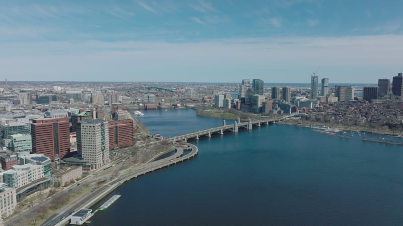 Slide and pan shot of Wide Charles river at Longfellow Bridge. Urban boroughs on waterfronts. Boston, USA