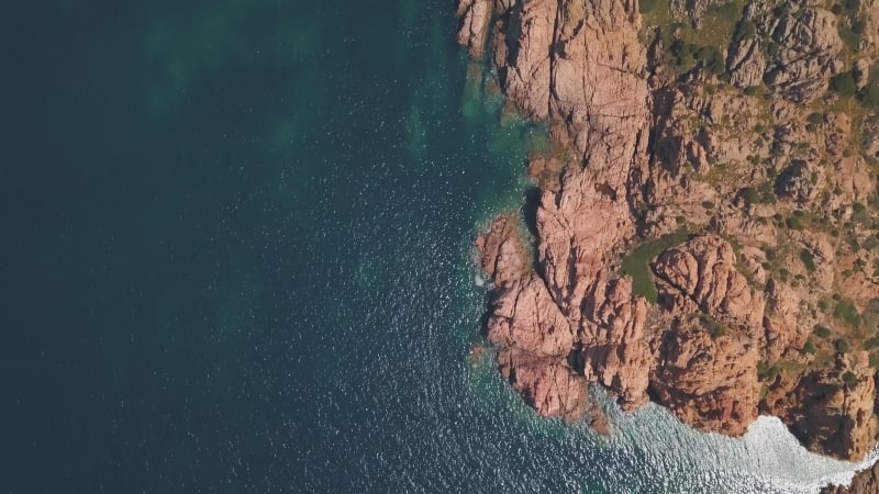 Aerial view of a reddish remote reef near Isola Rossa, Sardinia, Italy.