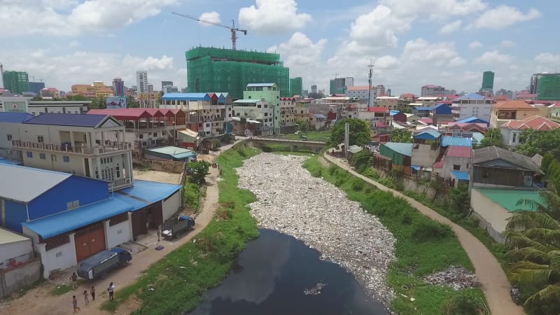 Aerial view of polluted river crossing city.