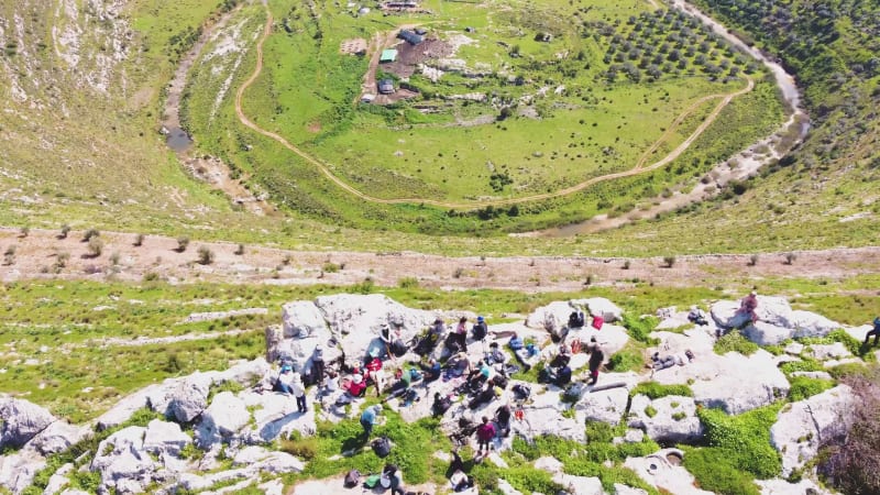 Aerial View of people admiring the landscape of the wooded hills and the paths.