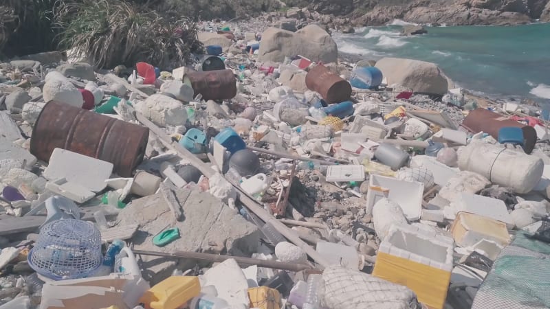 Environmental destruction caused by beach covered in plastic and rubbish causing climate change in Hong Kong. Aerial drone view