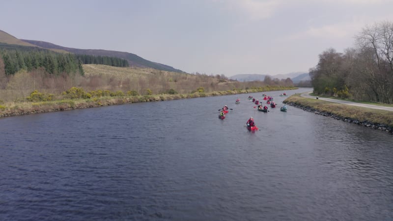 Low and Fast Aerial Shot of A Group of Canoeists Travelling Along a Canal