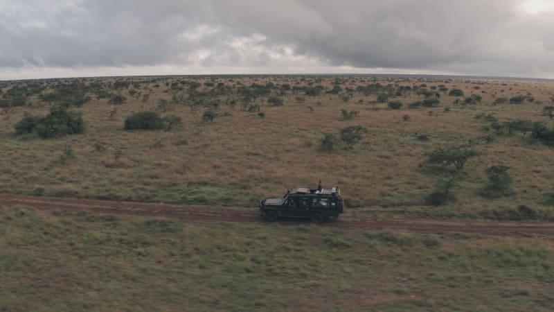 Aerial view of a woman on top of safari offroad vehicle in Africa