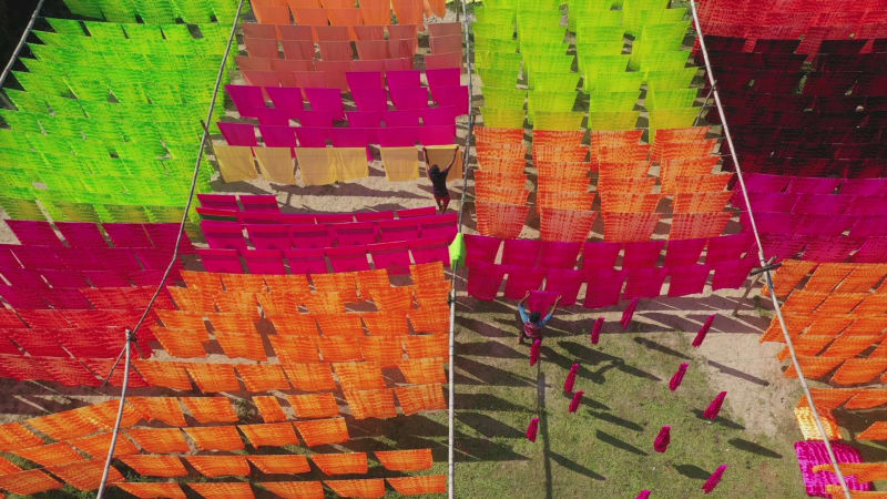 Aerial view of a man hanging colourful cloth in Araihazar, Dhaka, Bangladesh.