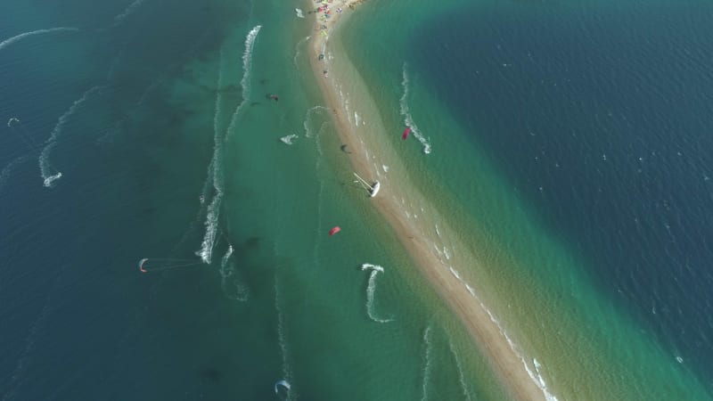 Aerial view faraway of group kitesurfing.