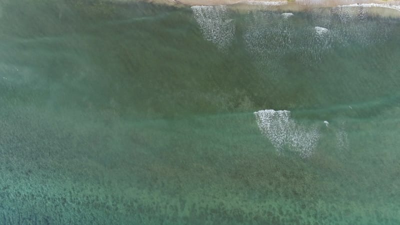 Aerial view above of transparent water beach.