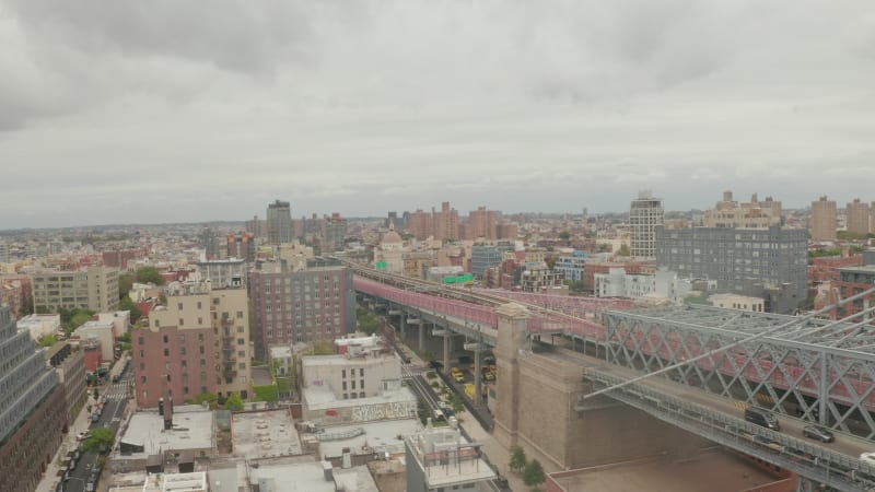 Flight over Williamsburg Bridge Brooklyn side with Car traffic and streets at cloudy day