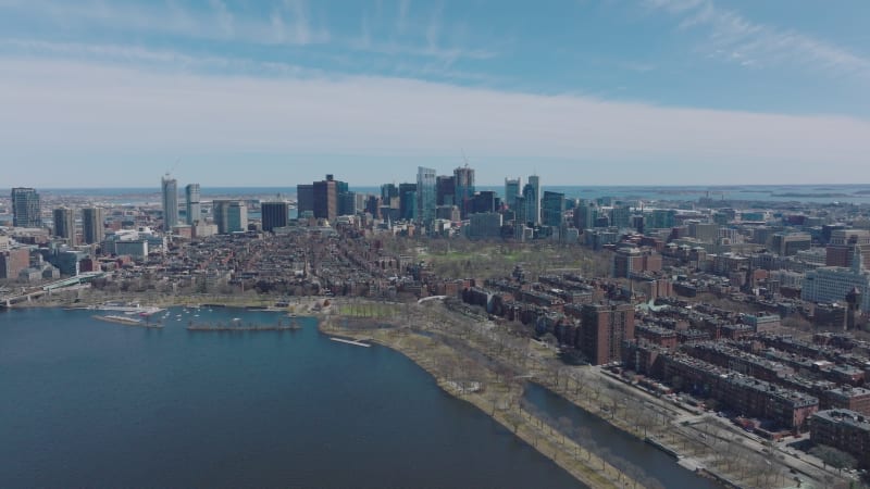 Red brick apartment buildings in residential neighbourhood on river waterfront and downtown skyscrapers in background. Boston, USA