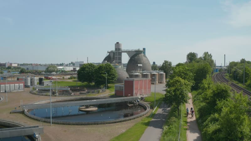 Rise up footage of industrial area. Aerial view of circle sump tanks in wastewater treatment plant. Luebeck, Schleswig-Holstein, Germany