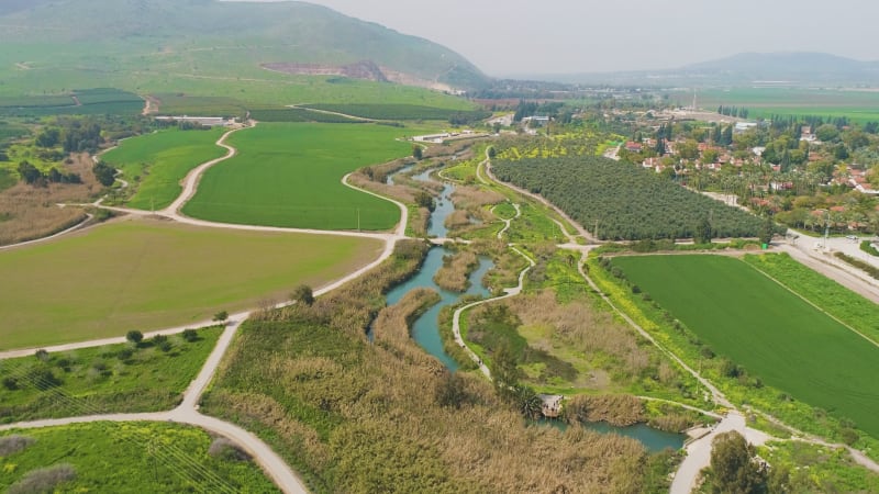 Aerial view of cultivated fields with hills in the background and Kibbutzim.