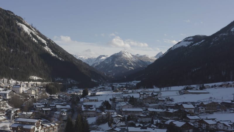 Idyllic snow covered mountain village surrounded by tall mountain peaks in Flachau, Austria