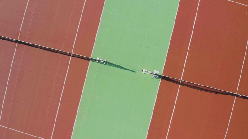 Rotating aerial view of the nets on two tennis courts