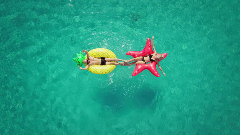 Aerial view of man and woman splashing each other.