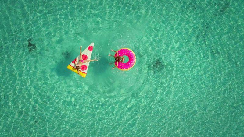 Close aerial view of two young girls swimming and playing.