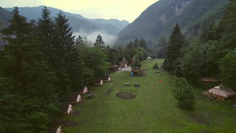 Aerial view of forest wooden cabins at an excursion camp.