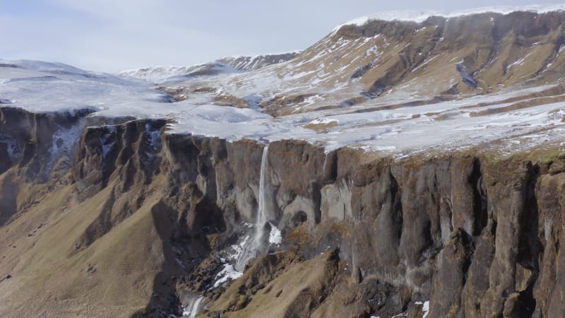 Small and Beautiful Waterfall on a Snowcapped Ledge in the Winter