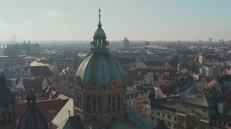 Close Up Aerial View of Cathedral church top with Christian cross and clock on tower, Beautiful Old Architecture in Munich, Germany, Drone Slide circle around building